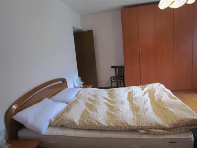 a bedroom with a bed and a wooden cabinet at Appartamenti Rumo in Rumo