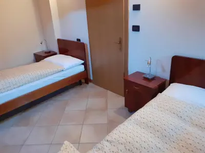 a room with two beds and two tables in it at Appartamenti Rumo in Rumo
