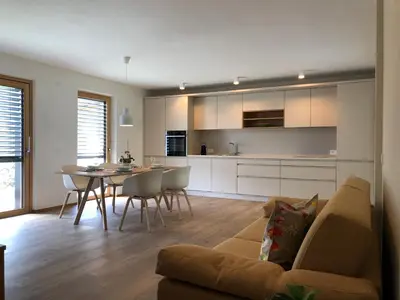 a living room and kitchen with a couch and a table at Apartment42 in Bressanone