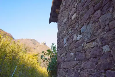 a stone wall next to a brick building at Unterbi Apartments in Appiano sulla Strada del Vino