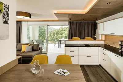 a kitchen and living room with a table and chairs at Panorama Residence Saltauserhof Resort in Saltusio