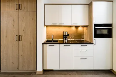 a kitchen with white cabinets and a sink at Panorama Residence Saltauserhof Resort in Saltusio