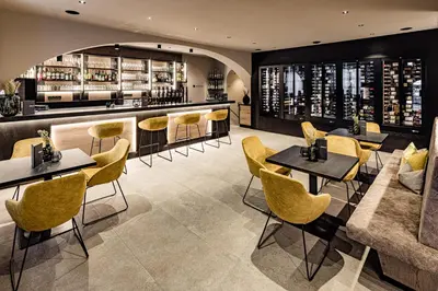 a restaurant with yellow chairs and tables and a bar at Panorama Residence Saltauserhof Resort in Saltusio