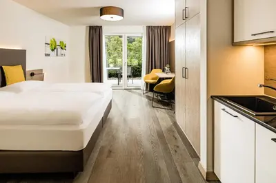 a hotel room with a large bed and a kitchen at Panorama Residence Saltauserhof Resort in Saltusio