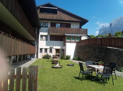 a courtyard of a building with a table and chairs at Pension Fellis in Vols am Schlern