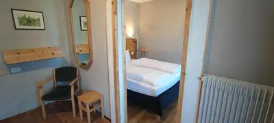 a small room with a bed and a mirror at Pension Fellis in Vols am Schlern