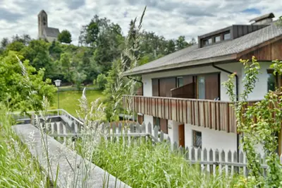a house with a fence next to a building at Pension Fellis in Vols am Schlern
