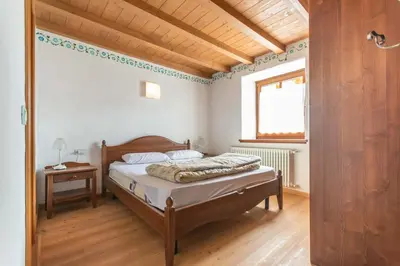 a bedroom with a bed and a window at Casa Roberto in Moena