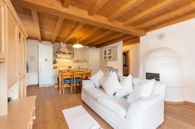 a living room with a white couch and a table at Casa Roberto in Moena