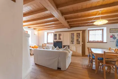 a living room with a couch and a table with chairs at Casa Roberto in Moena
