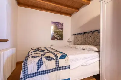 a bedroom with a bed with a blue and white quilt at Casa Roberto in Moena