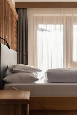 a bedroom with two beds in a room with wooden walls at Garni Ciasa Tamà Sas di Pezzedi Eriberto e Neumair Hermine in Corvara in Badia