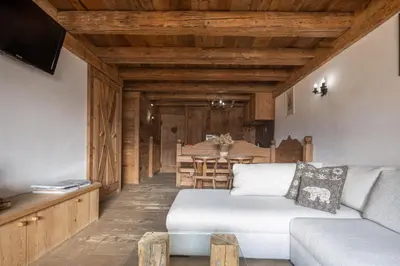 a living room with a couch and a table at Cortina Lodge Stunning View R&R in Cortina dʼAmpezzo