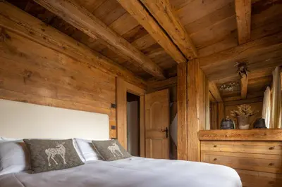 a bedroom with wooden walls and a bed in a room at Cortina Lodge Stunning View R&R in Cortina dʼAmpezzo