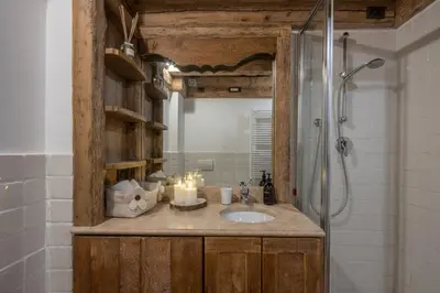 a bathroom with a sink and a shower with candles at Cortina Lodge Stunning View R&R in Cortina dʼAmpezzo
