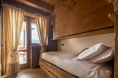 a bed in a room with wooden walls at Cortina Lodge Stunning View R&R in Cortina dʼAmpezzo