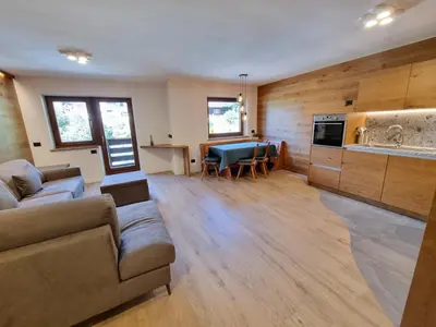 a living room with a couch and a kitchen at Val Fassa in Campitello di Fassa