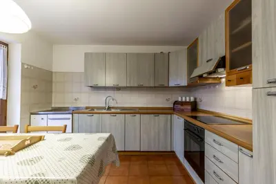 a kitchen with wooden cabinets and a table with a table sidx sidx at Val Fassa in Campitello di Fassa