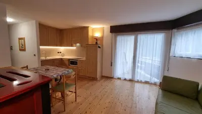 a kitchen with a table and a dining room at Salin in Campitello di Fassa