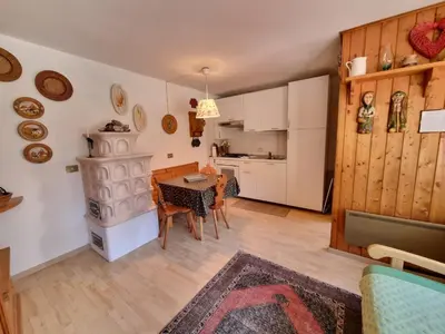 a kitchen and living room with a table and chairs at Salin in Campitello di Fassa