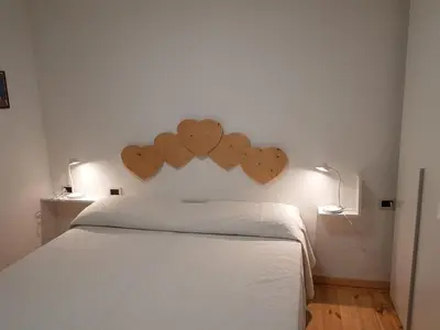 a bedroom with a bed with hearts on the wall at Salin in Campitello di Fassa