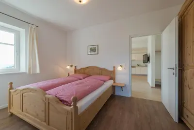 a bedroom with a large wooden bed with pink sheets at Mairhof in Missiano
