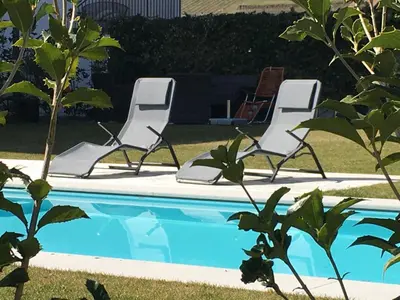 three chairs and a swimming pool in a yard at Mairhof in Missiano