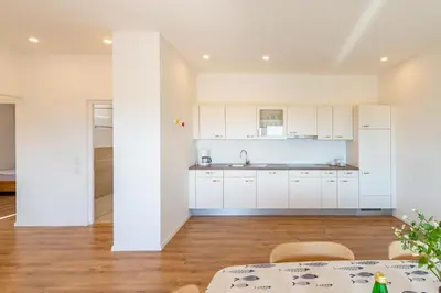an open kitchen with white cabinets and a table at Mairhof in Missiano