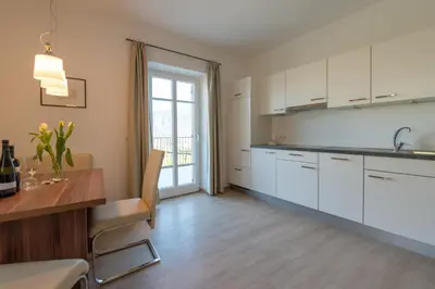 a kitchen with white cabinets and a wooden table at Mairhof in Missiano
