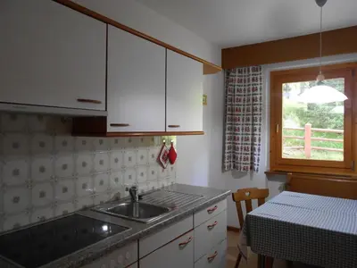 a kitchen with a sink and a table and a window at Aria d'Bosch in Badia
