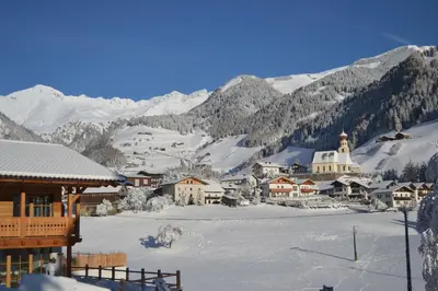 a town in the snow with mountains in the background at Bergidyll an der Lane - Pfunders in Fundres