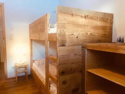 a bedroom with bunk beds in a room with a table at Bergidyll an der Lane - Pfunders in Fundres