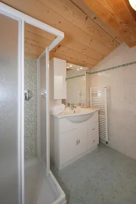 a bathroom with a white sink and a shower at Casa Seler - Appartamento verde in Predazzo