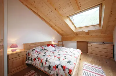 a bedroom with a bed and a window at Casa Seler - Appartamento rosso in Predazzo