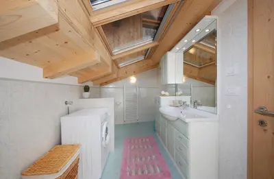 a bathroom with a white sink and a wooden ceiling at Casa Seler - Appartamento rosso in Predazzo