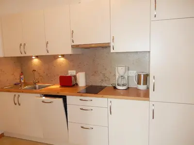 a kitchen with white cabinets and a sink at Garni Sonnleiten in Tirolo