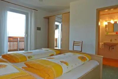 two beds in a room with a balcony at Garni Sonnleiten in Tirolo