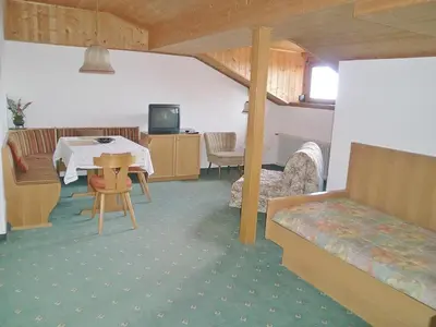 a living room with a table and a couch at Garni Sonnleiten in Tirolo