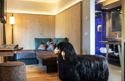 a living room with a large black dog statue in front of a couch at Hotel Paradies in Tires