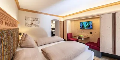 a hotel room with two beds and a desk at Hotel Paradies in Tires