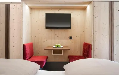 a room with two beds and a tv on a wall at Hotel Paradies in Tires