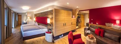 a bedroom with a bed and a red wall at Hotel Paradies in Tires