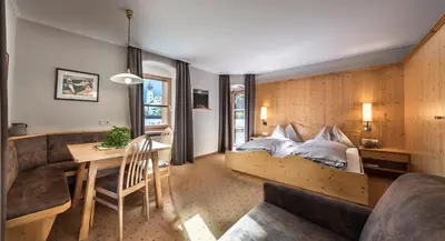 a bedroom with a bed and a table and a couch at Hotel Paradies in Tires