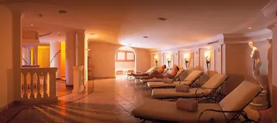 a lobby with couches and chairs in a building at Hotel Garni Dolomieu in Selva di Val Gardena