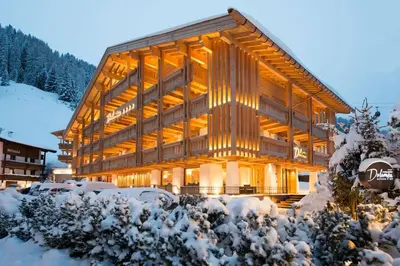 a building with flower boxes on the side of it at Hotel Garni Dolomieu in Selva di Val Gardena