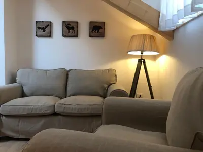 a living room with a couch and a lamp at Piano C Apartment in Cavalese