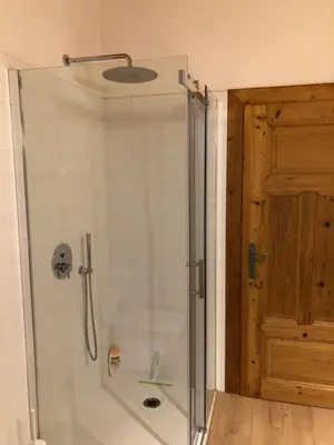 a shower with a glass door in a bathroom at Piano C Apartment in Cavalese