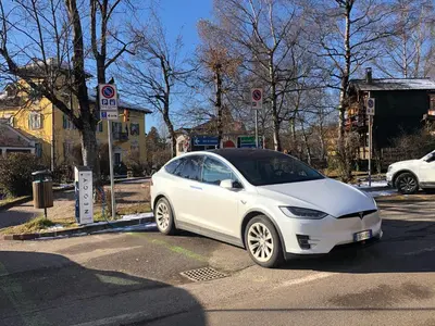 a white car parked on a street at Piano C Apartment in Cavalese
