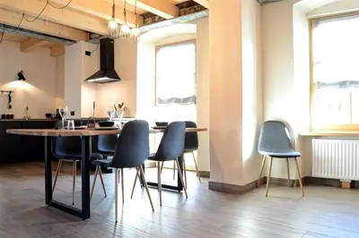 a dining room with a table and blue chairs at Apartment El Molin - Alpe Cermis Dolomites in Cavalese