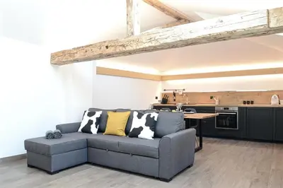 a living room with a couch and a kitchen at Apartment El Molin - Alpe Cermis Dolomites in Cavalese